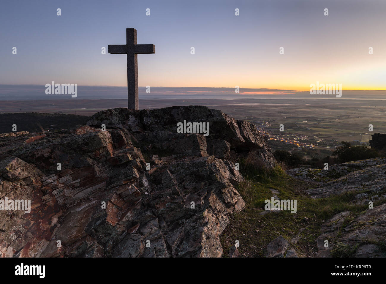 Dawn with cross in the foreground next to Sierra de Fuentes. Spain. Stock Photo