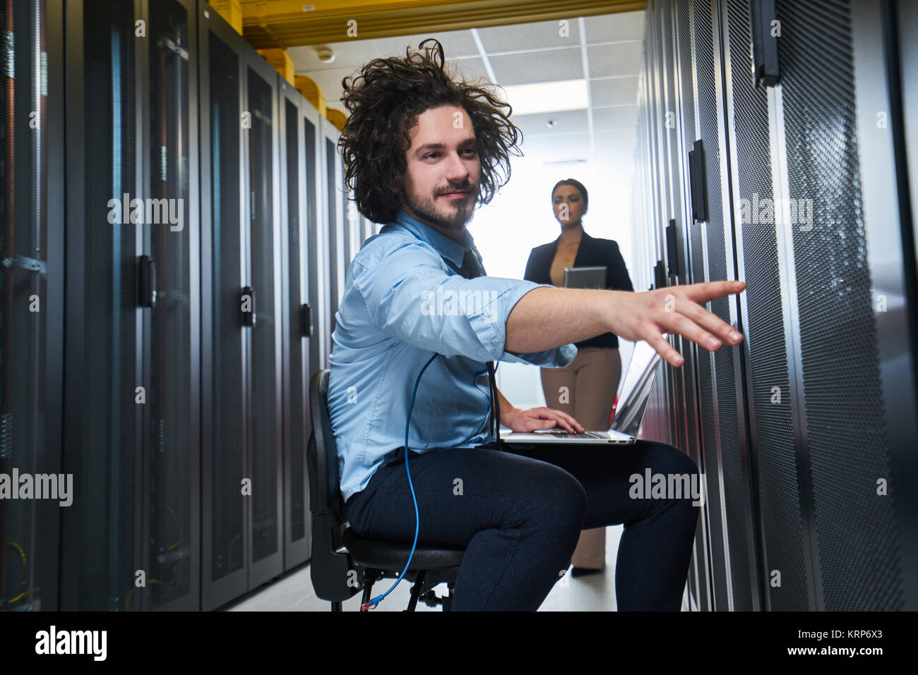 two young technicians working at a data center on server maintenance ...