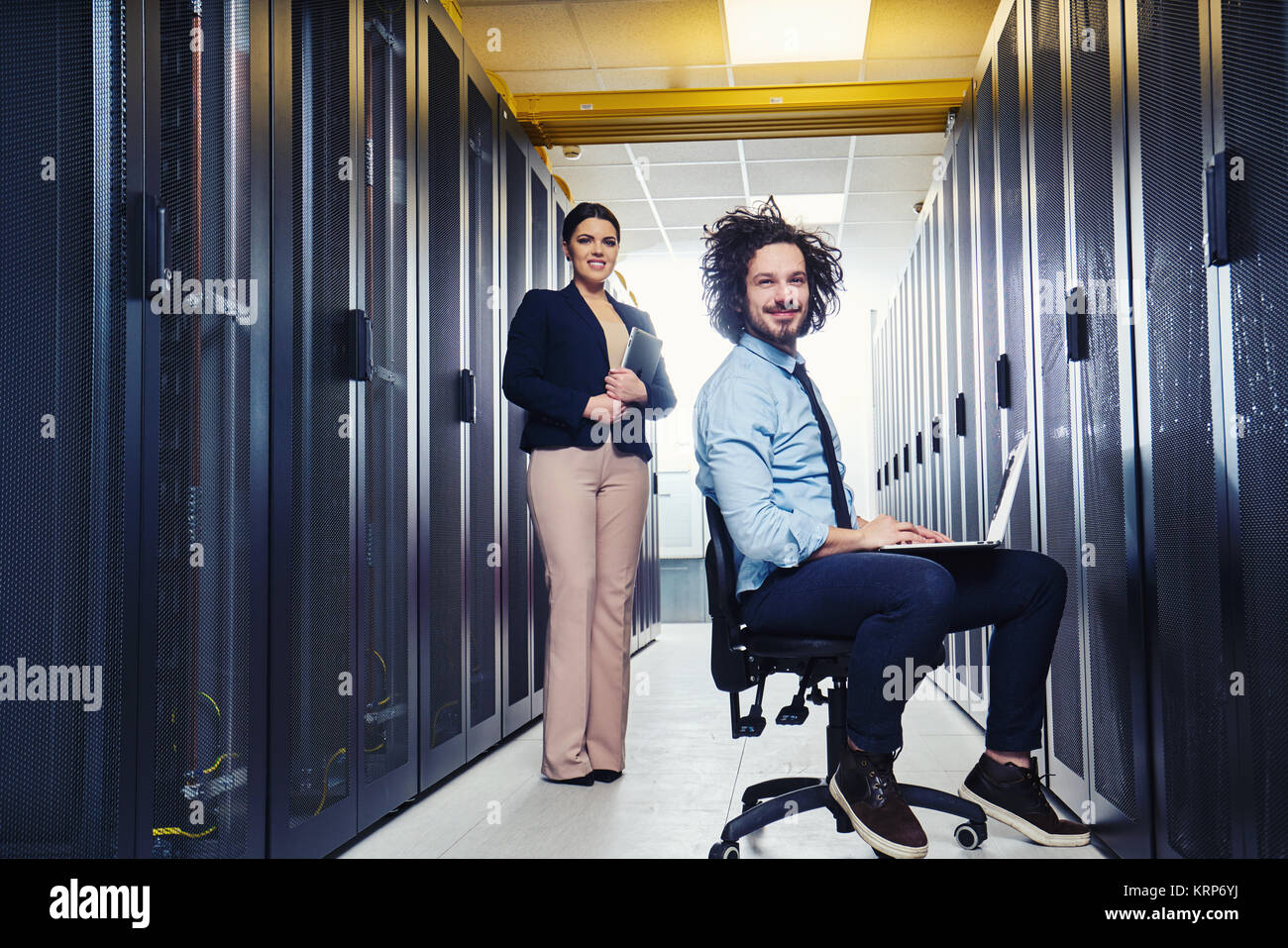 two young technicians working at a data center on server maintenance ...