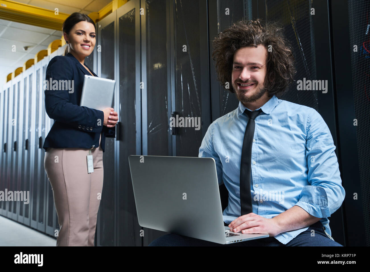 two young technicians working at a data center on server maintenance ...
