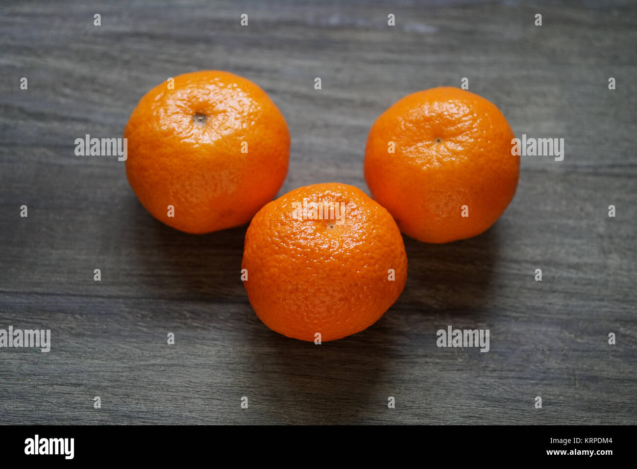 clementines or mandarin oranges on rustic wooden table Stock Photo