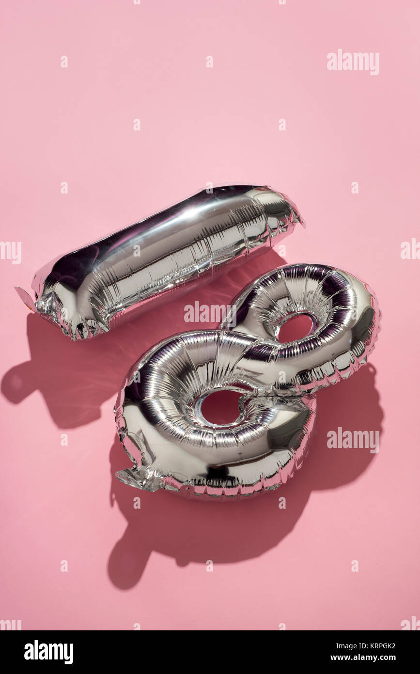 some silvery number-shaped balloons forming the number 18 against a