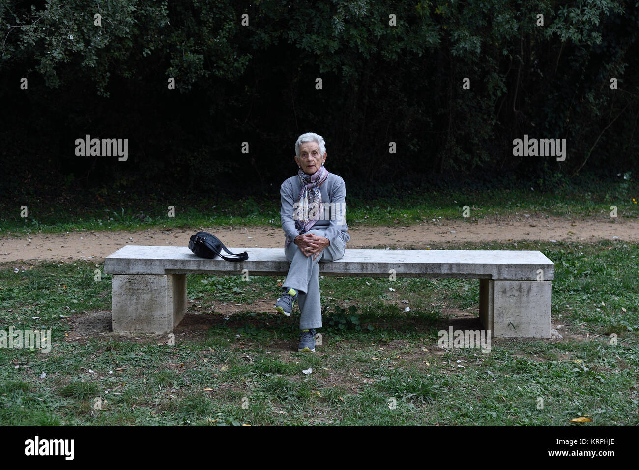 senior woman sitting alone on a bench in a park Stock Photo - Alamy