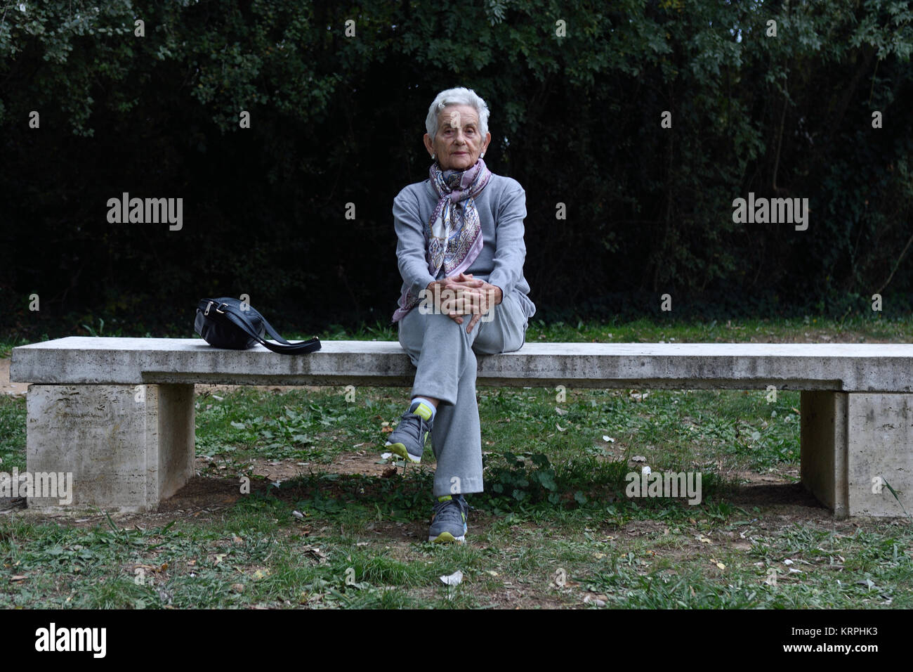 senior woman sitting alone on a bench in a park Stock Photo - Alamy