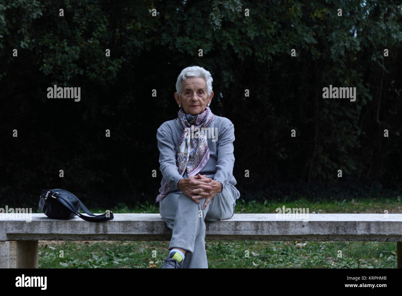 senior woman sitting alone on a bench in a park Stock Photo - Alamy