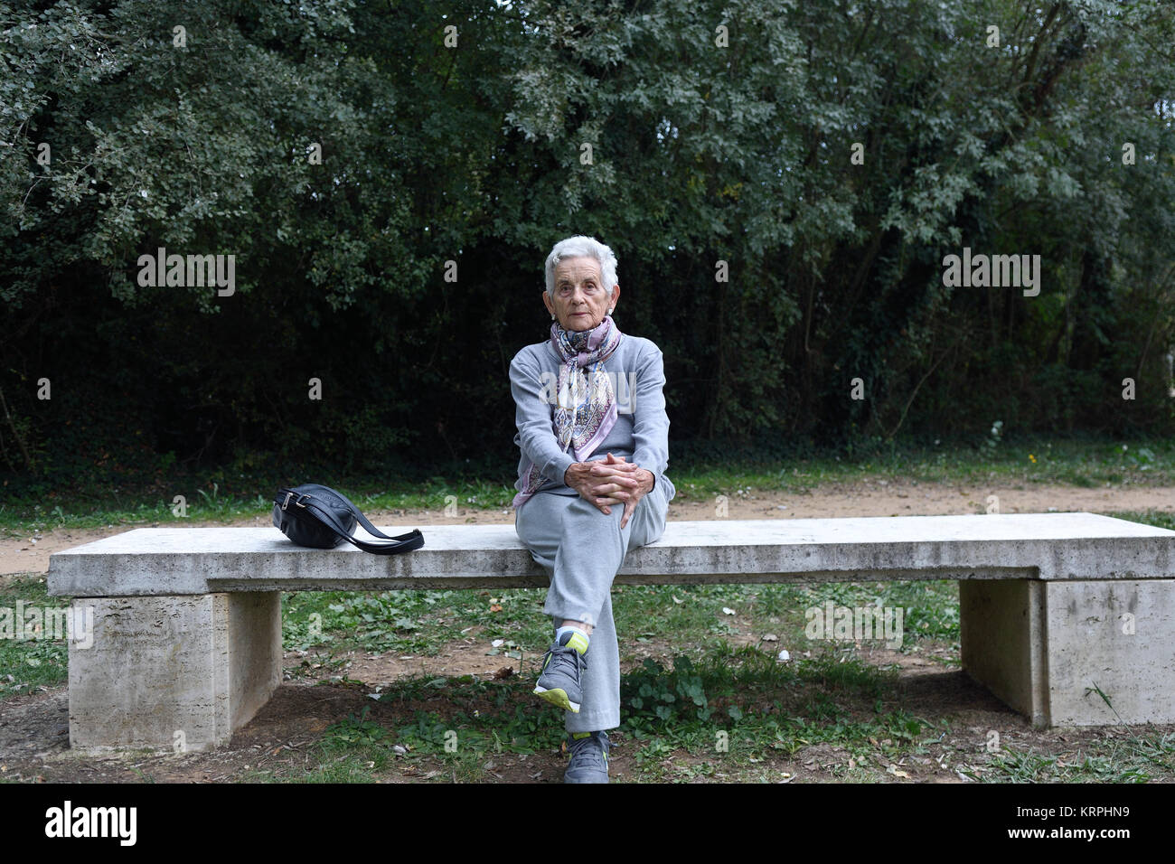 senior woman sitting alone on a bench in a park Stock Photo - Alamy