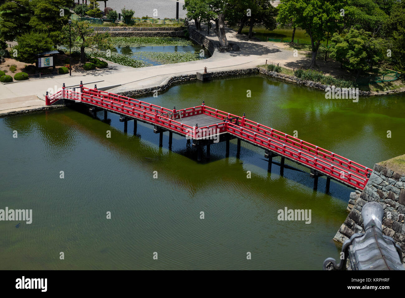 Matsumoto - Japan, June 6, 2017: Red bridge over the moat seen from the Castle Matsumoto also known as the Crow Castle. Stock Photo