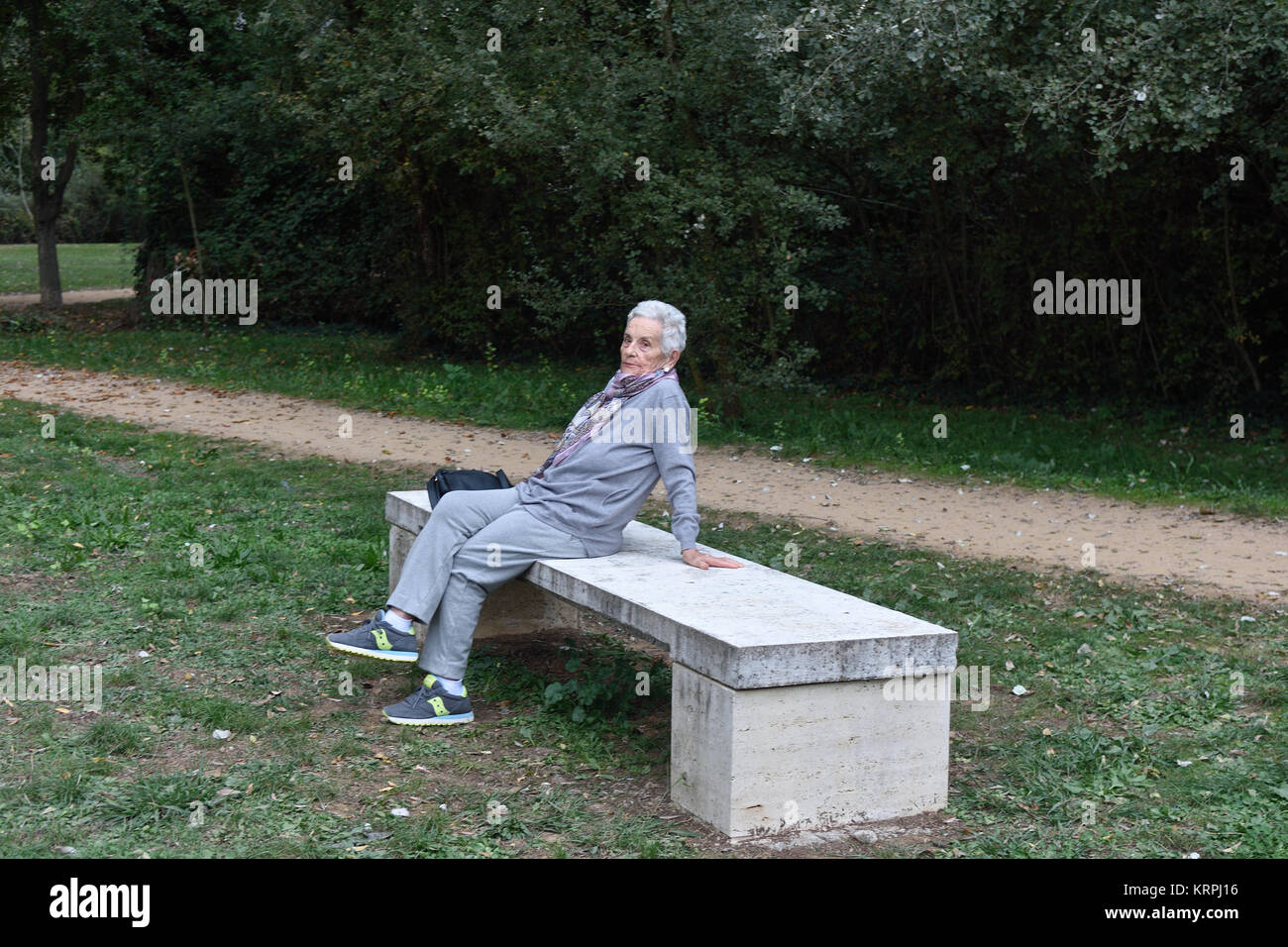 senior woman sitting alone on a bench in a park Stock Photo - Alamy