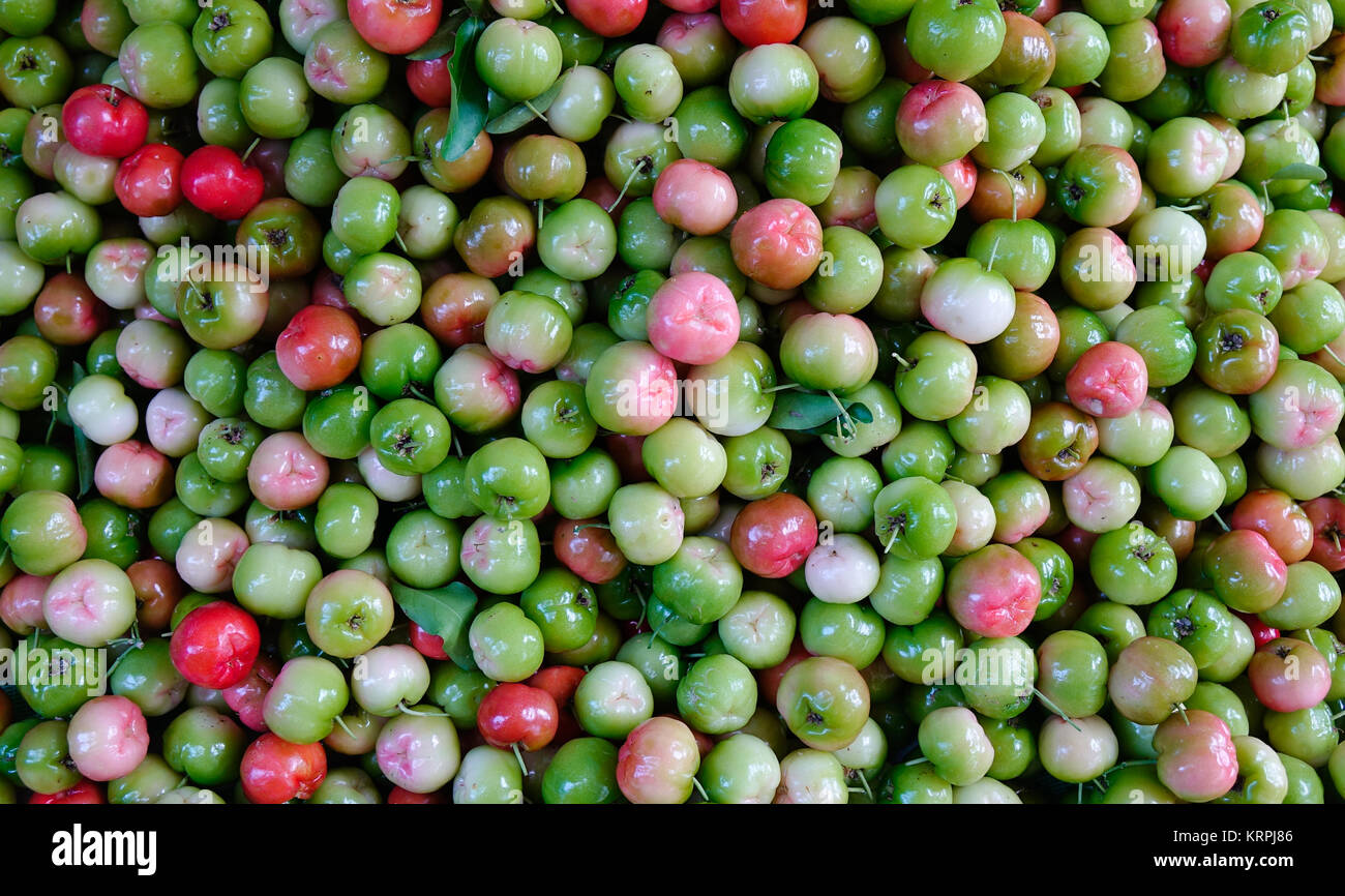 Malpighia glabra (red acerola) tropical fruits at local market. Close up. Stock Photo
