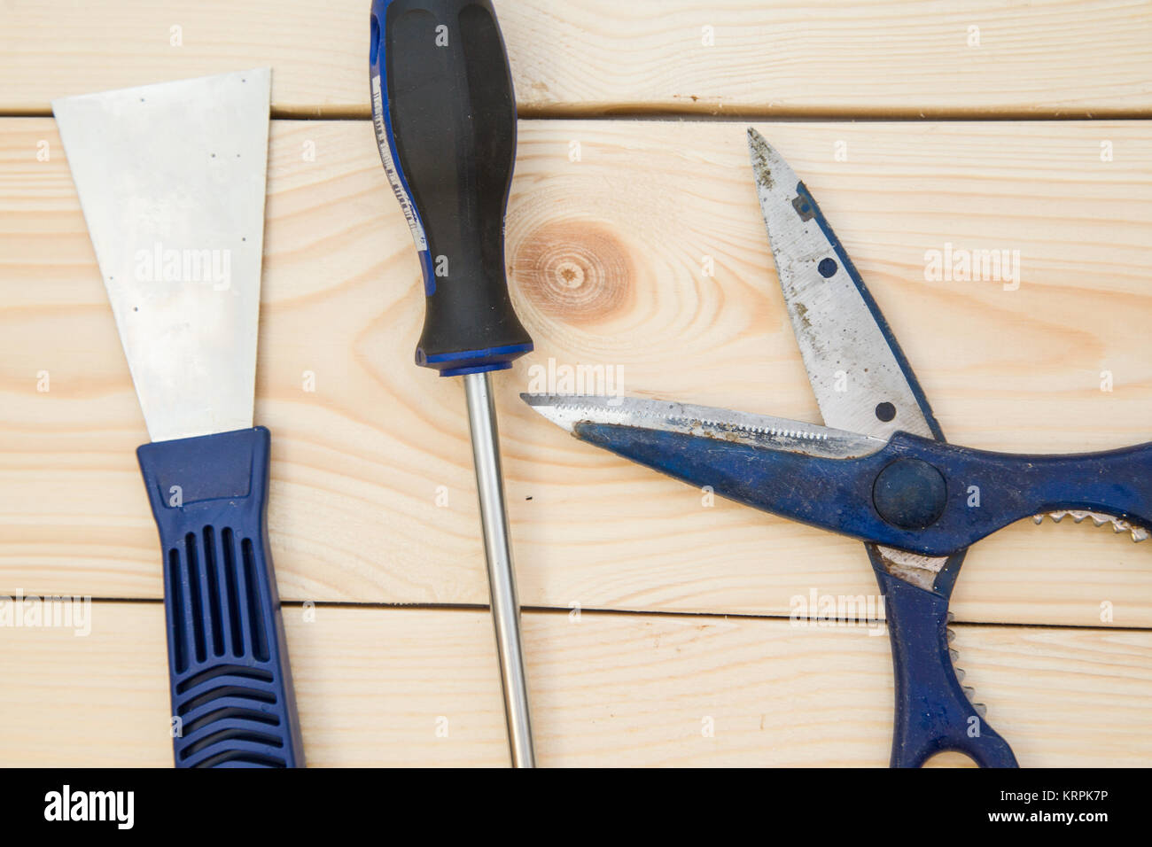 Repairing and construction concept. A set of tools for house repair-a plastering trowel, scissors and screwdriver on a light uncolored wooden backgrou Stock Photo