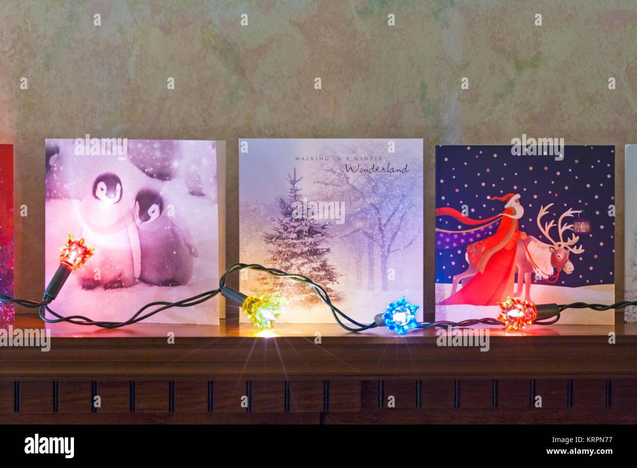 Row of christmas cards with christmas lights on mantelpiece hires stock photography and images