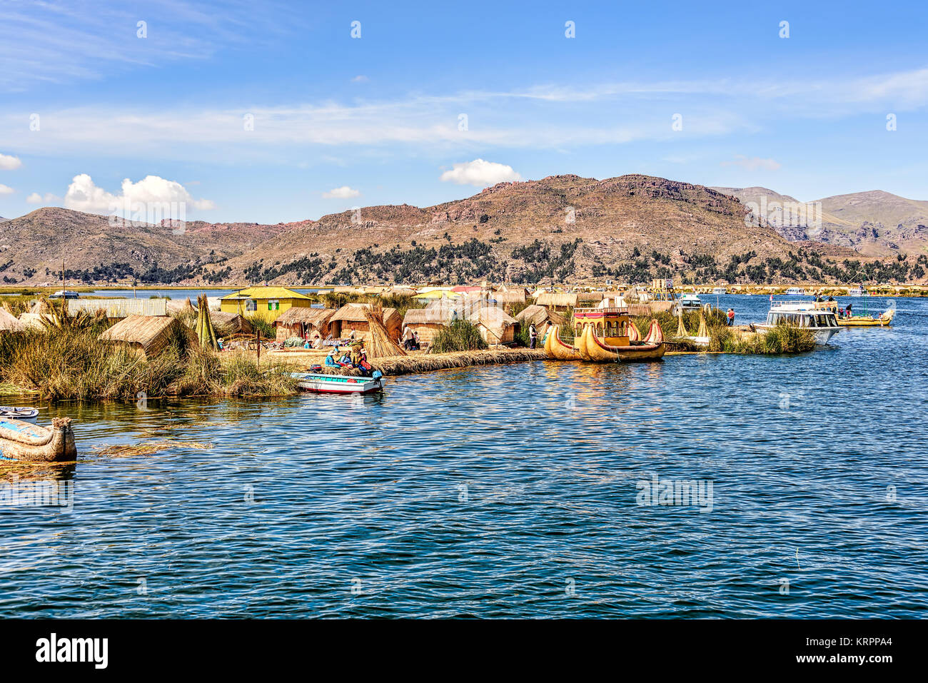 Floating islands made from reeds on Lake Titicaca under blue skies with scattered white clouds Stock Photo