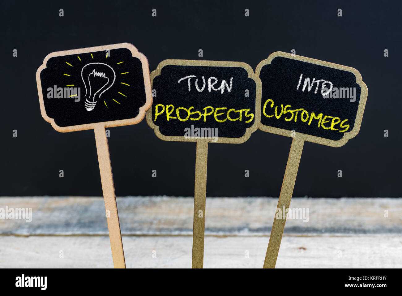 Concept message TURN PROSPECTS INTO CUSTOMERS and light bulb as symbol for idea Stock Photo