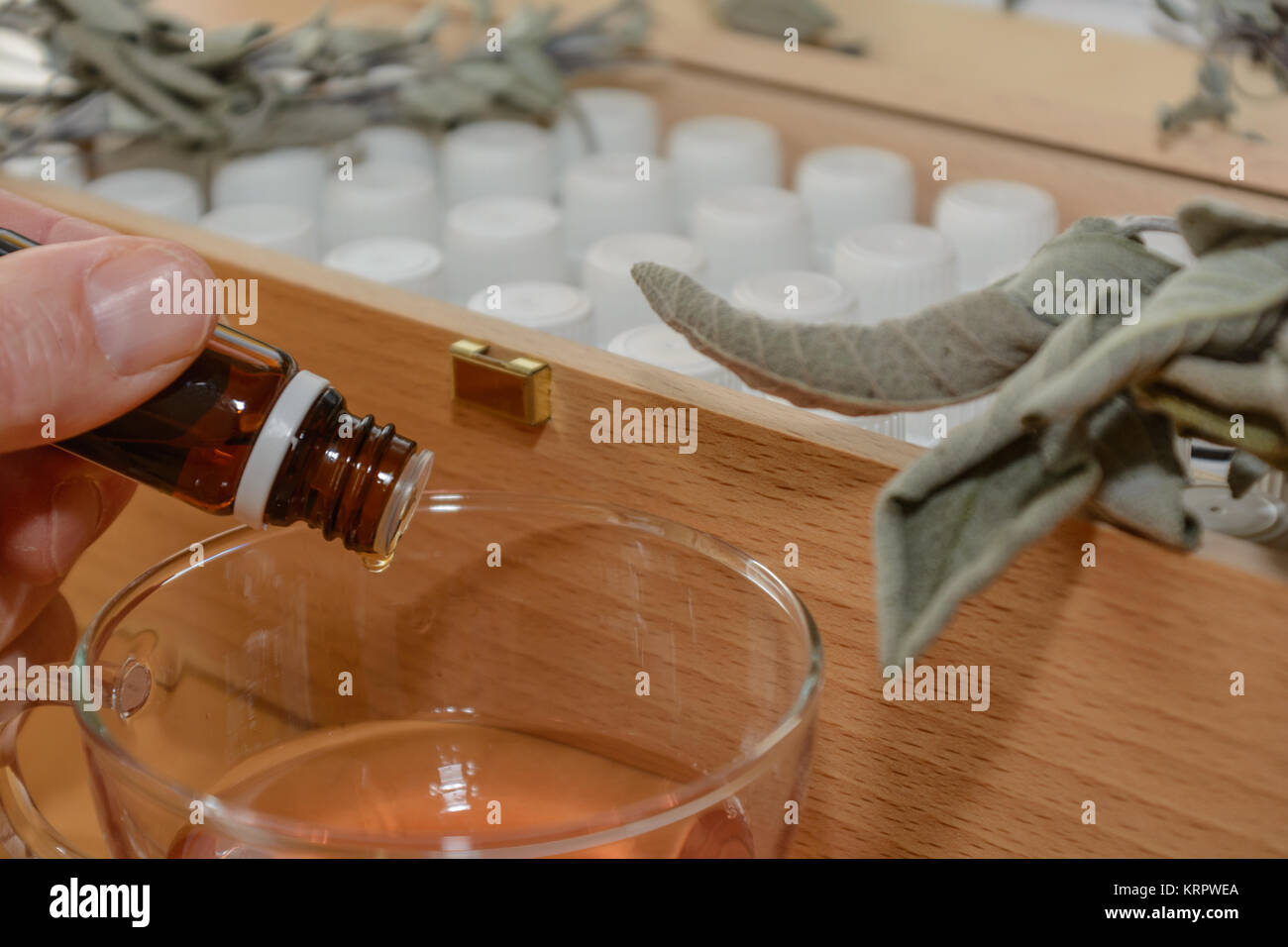 Aus braunem Arzneifläschchen gibt Person Tropfen Flüssigkeit in Saft Stock Photo