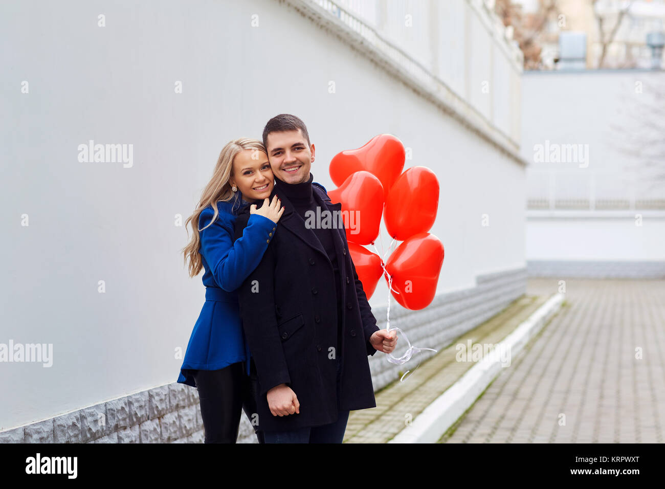 Loving couple with red heart balloons on the street Stock Photo - Alamy