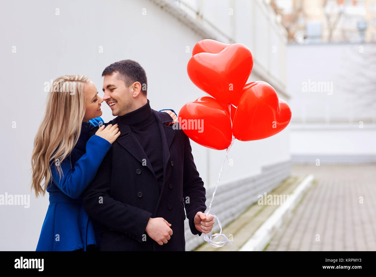 Loving couple with red heart balloons on the street Stock Photo - Alamy