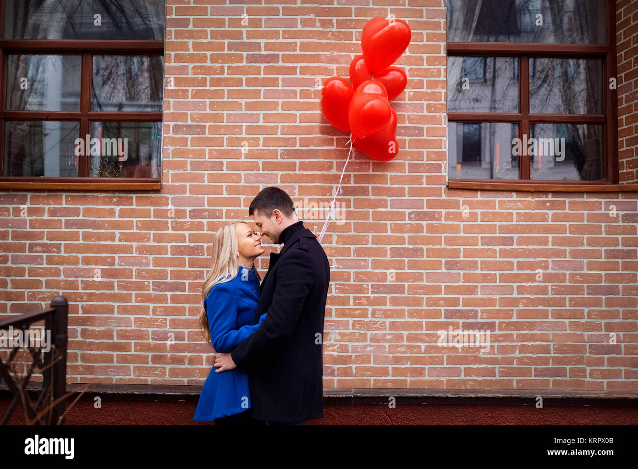 A loving couple with red heart ballons Stock Photo - Alamy