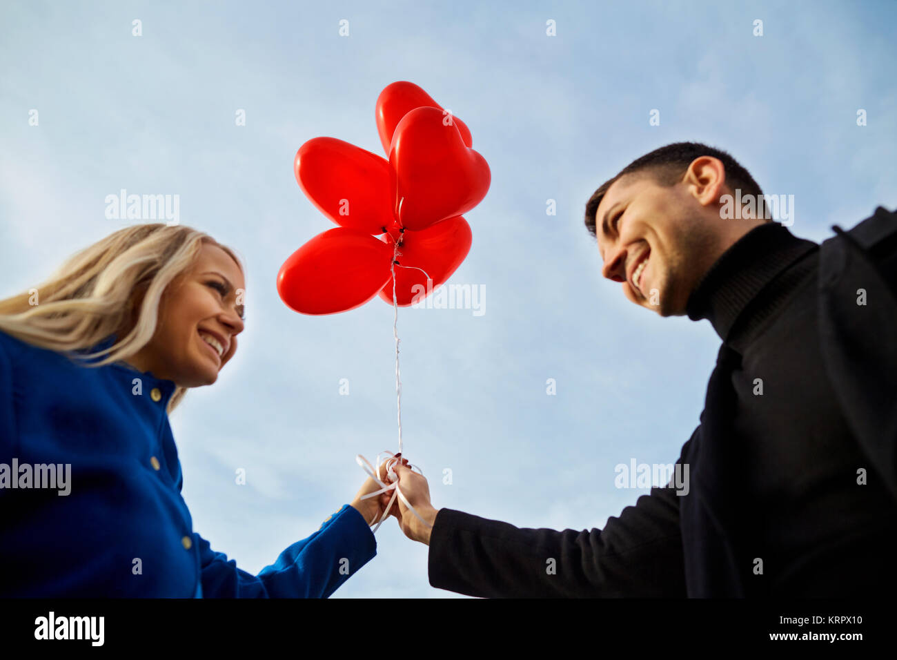 A loving couple with balloons against the blue sky Stock Photo - Alamy