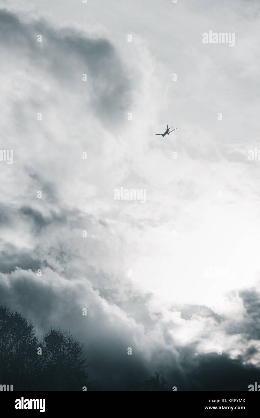 Aeroplane flying in a cloudy sky Stock Photo - Alamy