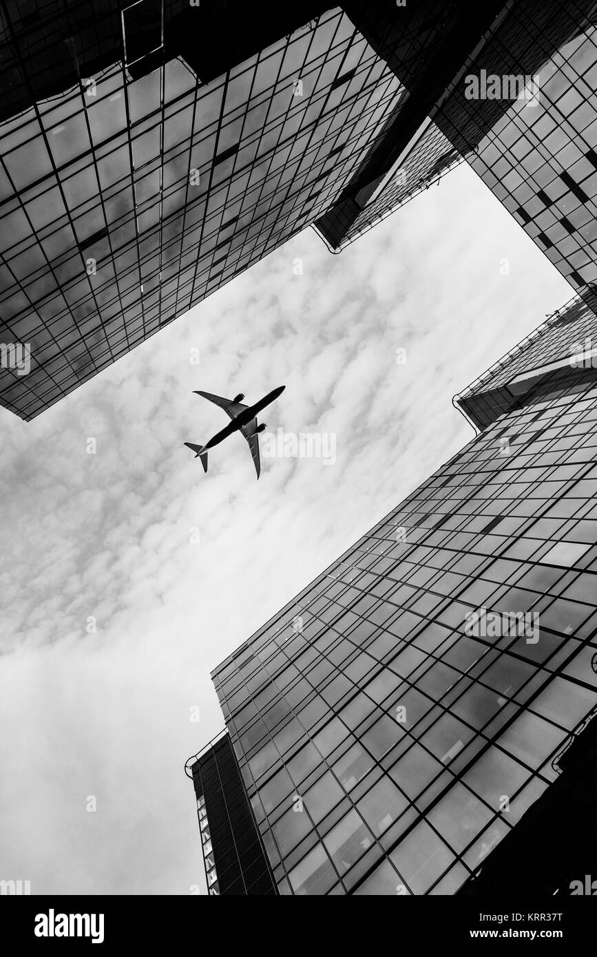 Airplane flying over business area. Stock Photo