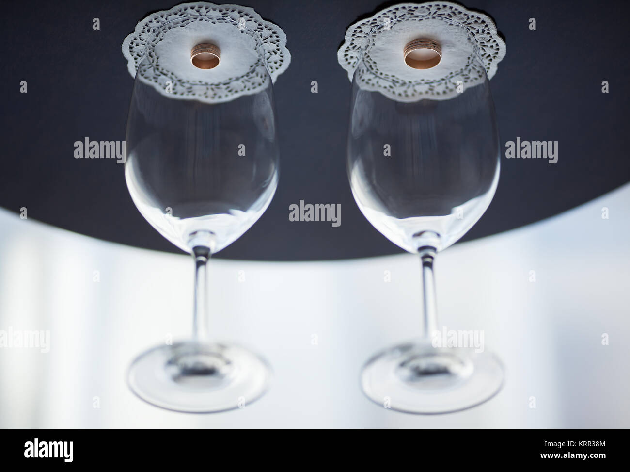 Wedding rings are covered with glasses for wine. Stock Photo