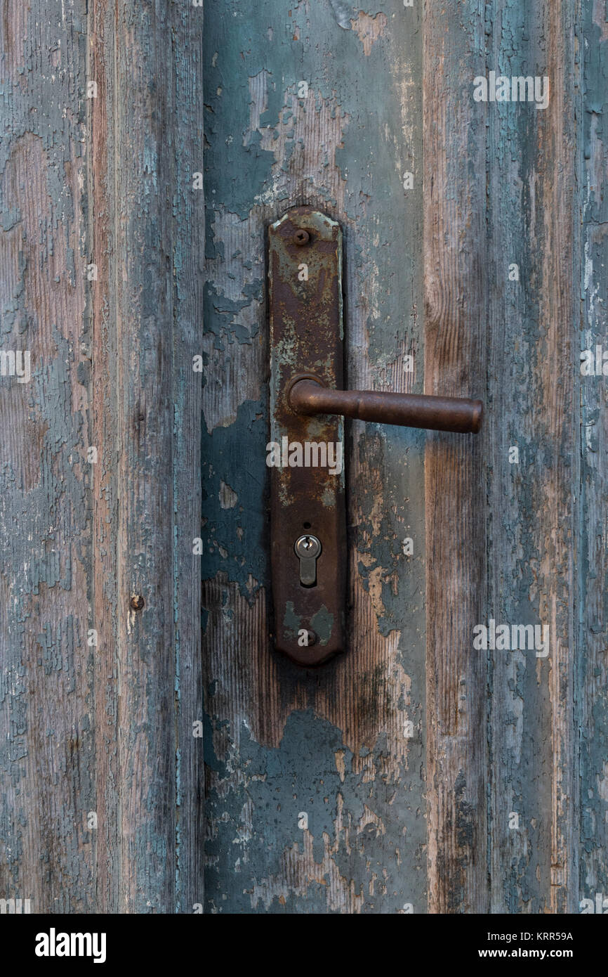 Old vintage metal door handle on old blue wooden doors. Rusty door