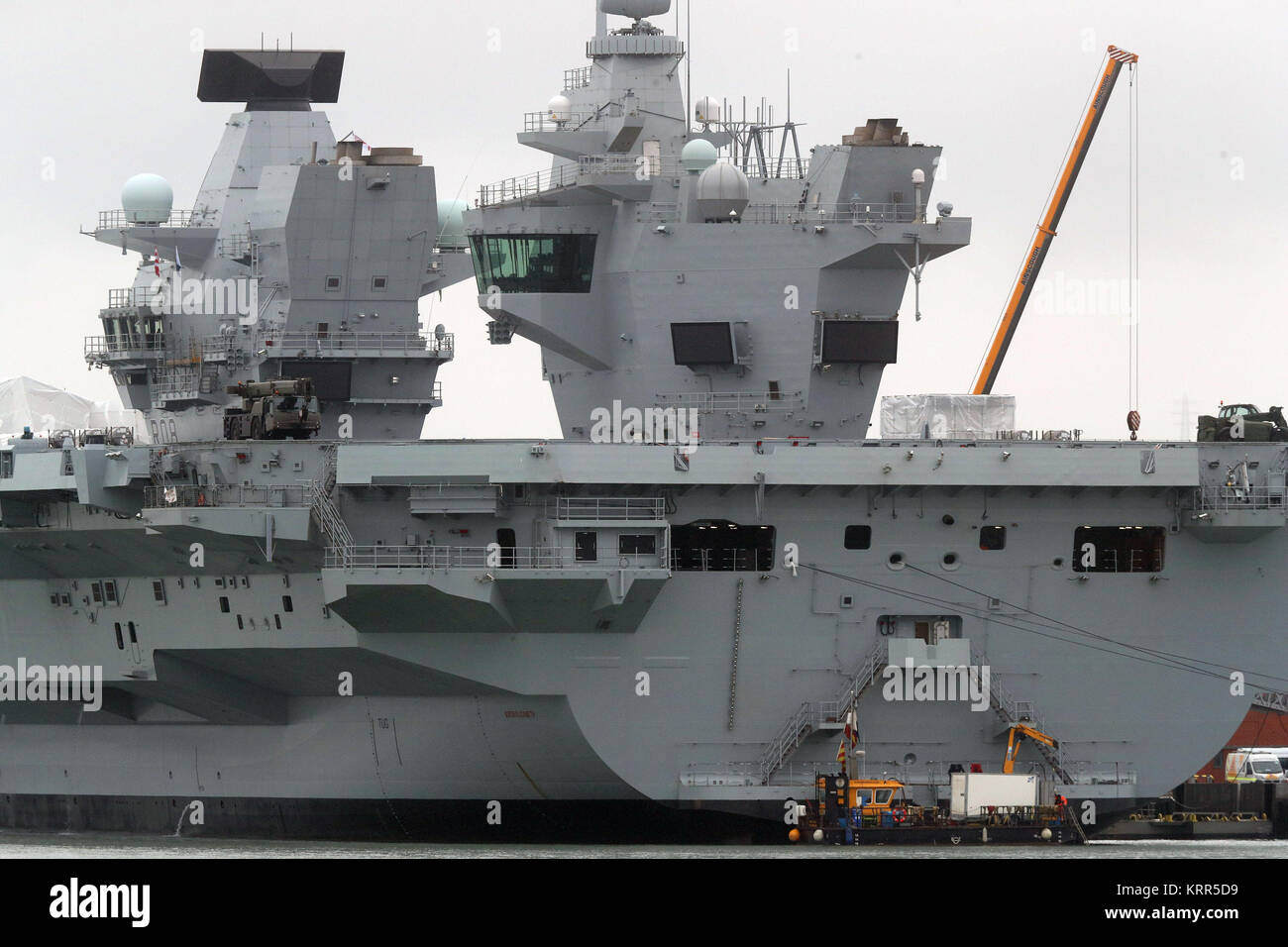 A Multicat support vessel at the stern of HMS Queen Elizabeth, after it was announced there was a leak from one of her propeller shafts. Stock Photo