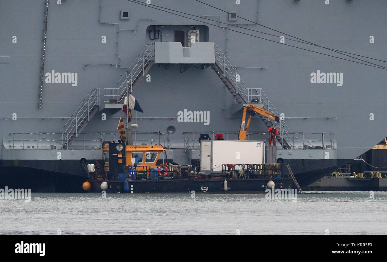 A Multicat support vessel at the stern of HMS Queen Elizabeth, after it was announced there was a leak from one of her propeller shafts. Stock Photo