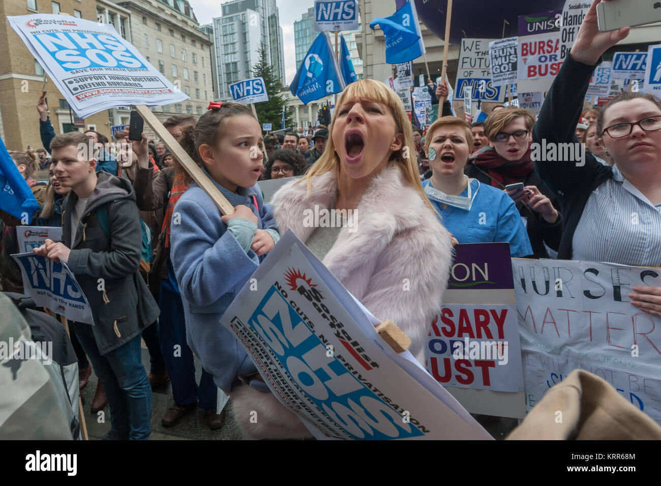 A woman holding a child is among those shouting support before the march to save NHS Student Bursaries. Stock Photo