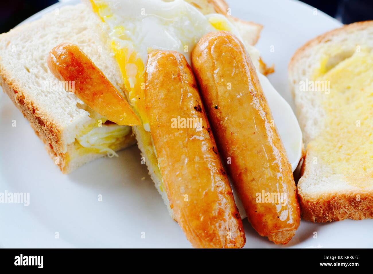 Sausage and fried egg breakfast sandwich on white bread - filter ...