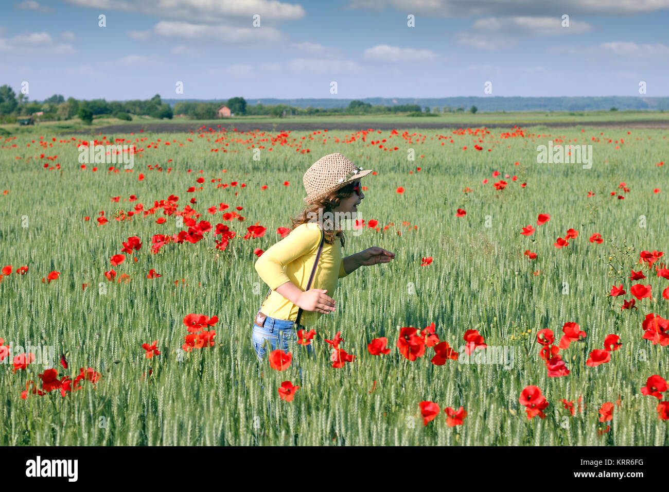 happy little girl runs through a field of green wheat Stock Photo - Alamy