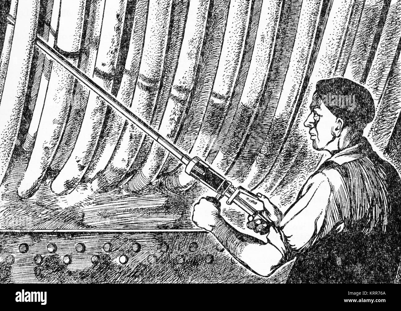 Engraving of a man cleaning the inside of a boiler with a percussion lance. From an engraving made in the 1880s. Stock Photo