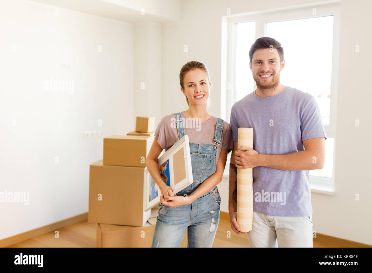 happy couple with boxes moving to new home Stock Photo - Alamy