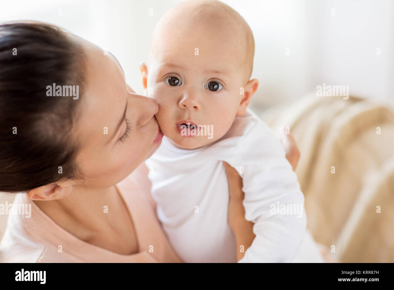 happy mother kissing little baby boy at home Stock Photo