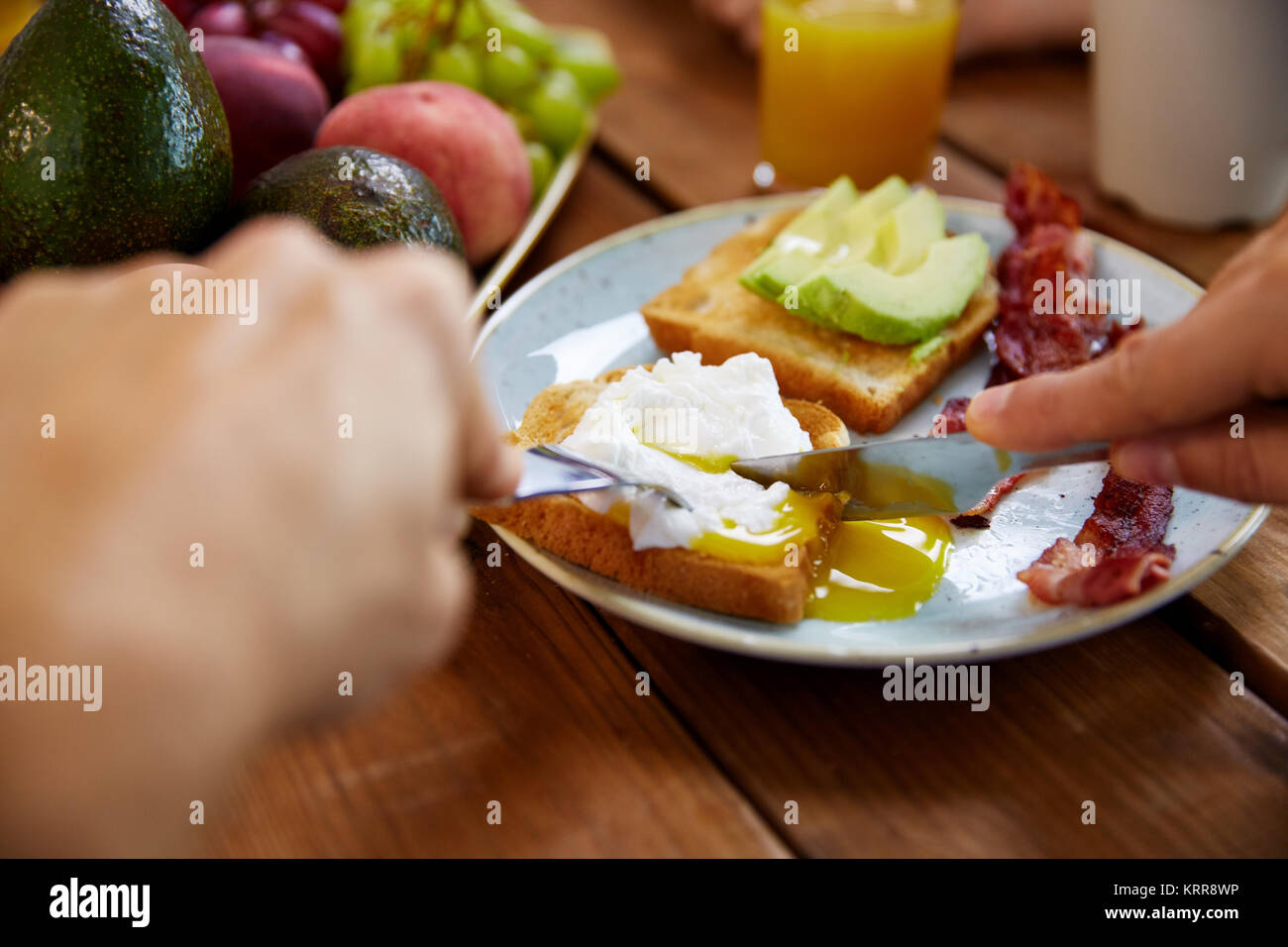 man eating toast with pouched egg and bacon Stock Photo