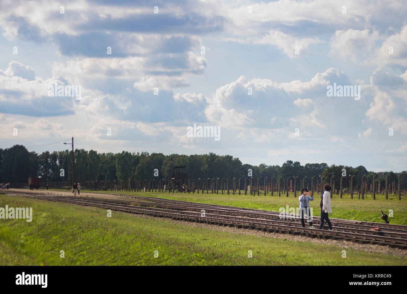 Tourists posing for a photo in front of Auschwitz concentration camp
