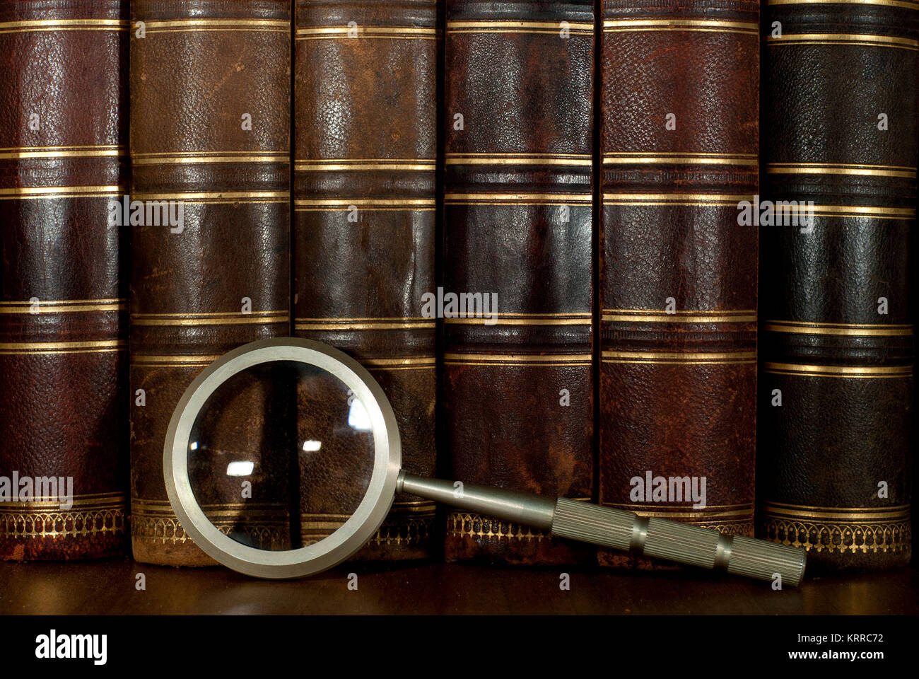 background a row of worn leather antiquarian book spines with gold