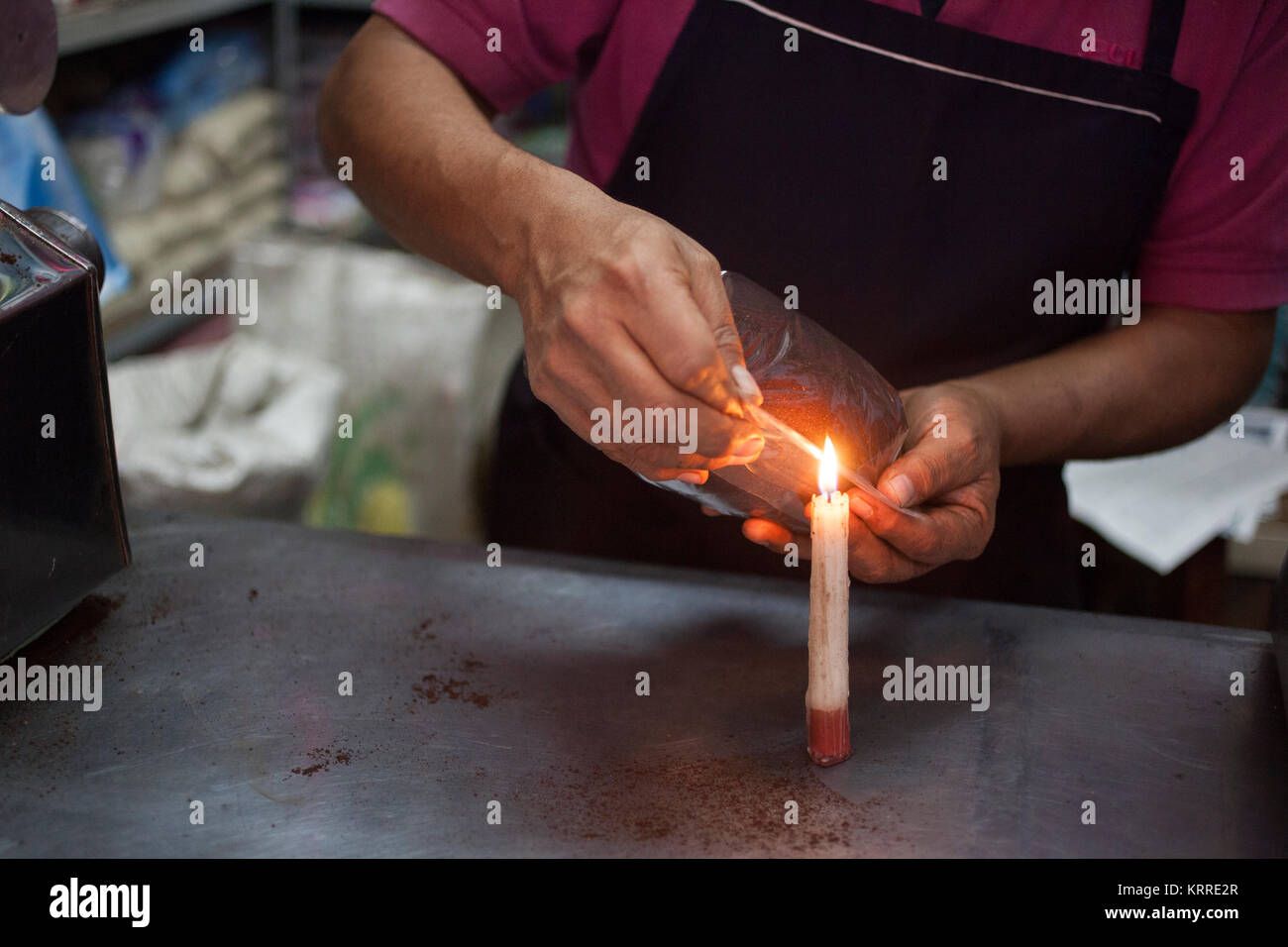 Coffee vendor sealing coffee bag with flame,Mercado Benito Juárez, Oaxaca City,  Oaxaca, Mexico Stock Photo