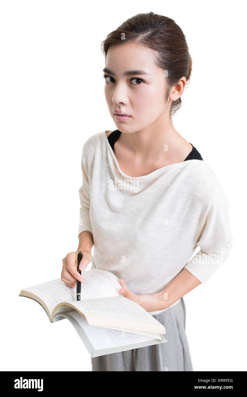 Serious young female teacher teaching with textbook Stock Photo