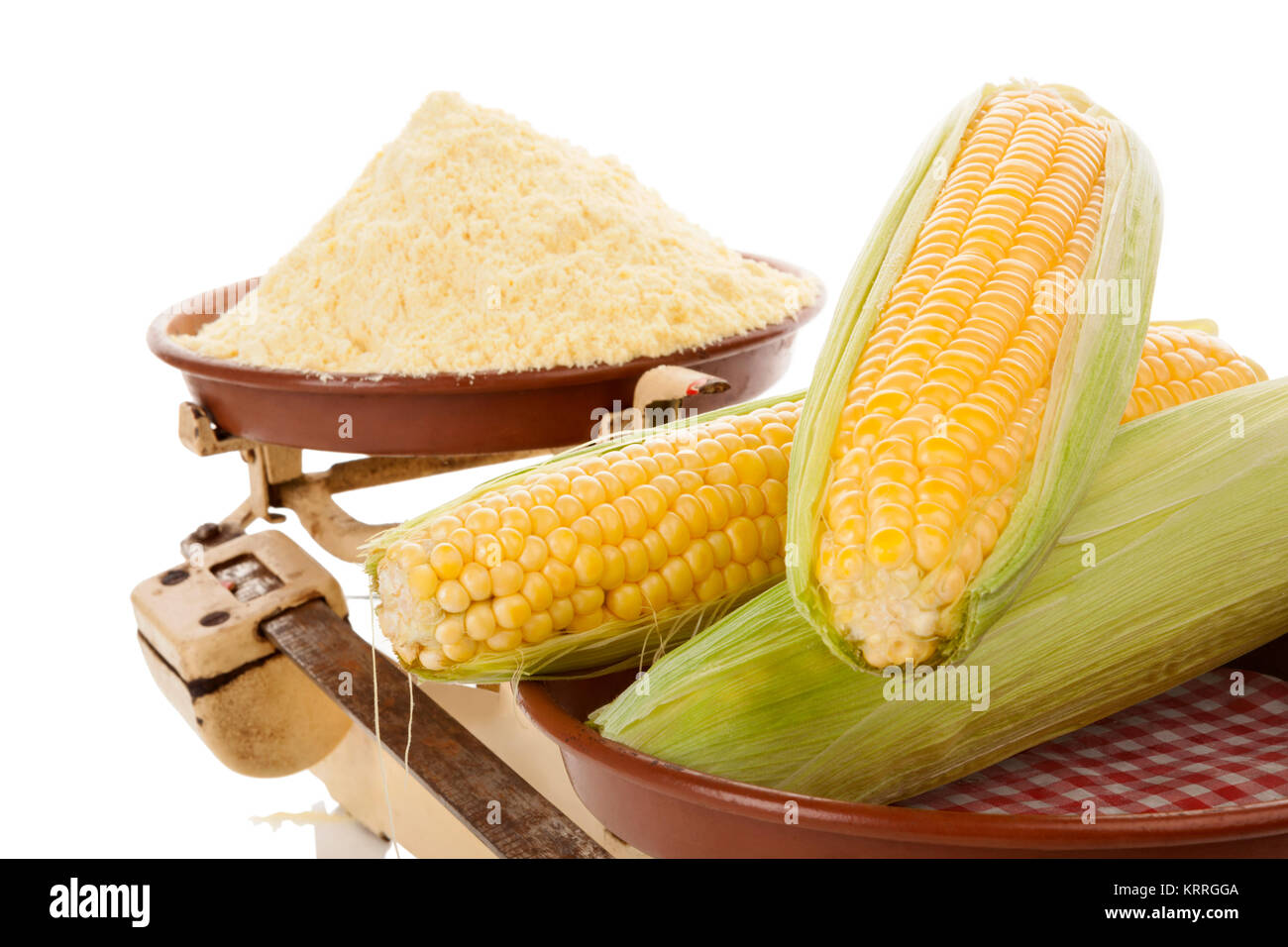 Corn cobs with corn flour on vintage weight scale. Isolated on white