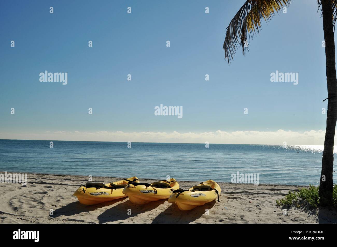 Ocean kayaks on sandy beach shoreline at sunrise over Atlantic Ocean