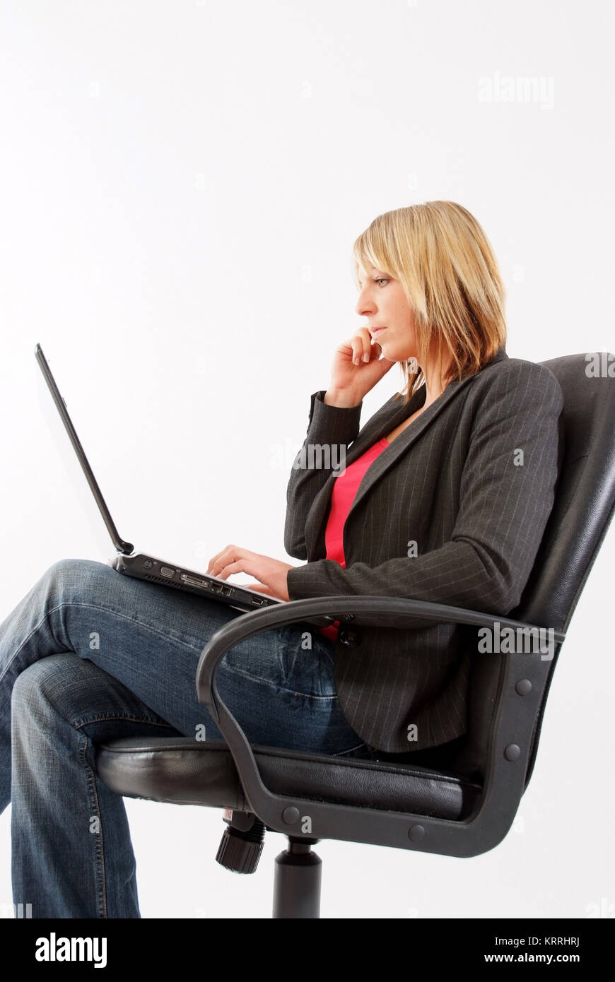 Junge Geschaeftsfrau mit Laptop im Chefsessel - young businesswoman in executive chair Stock Photo