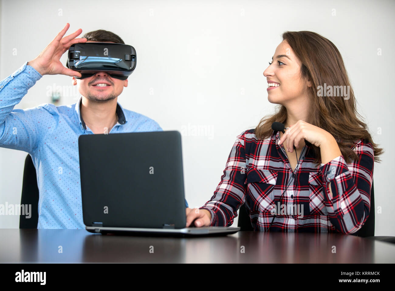 Couple having fun trying VR headset at startup meeting, concept ...