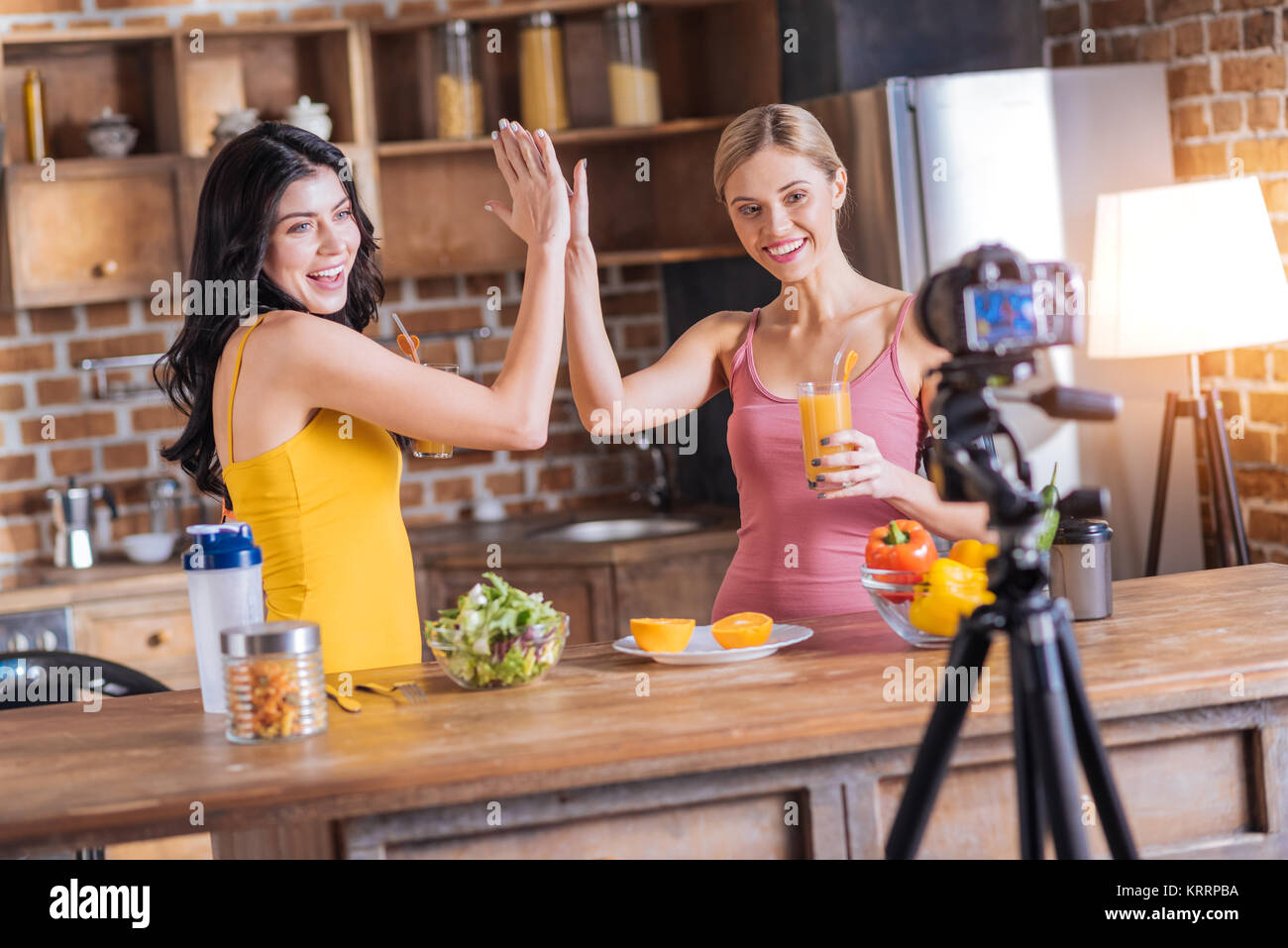 Delighted pretty women giving each other high five Stock Photo - Alamy