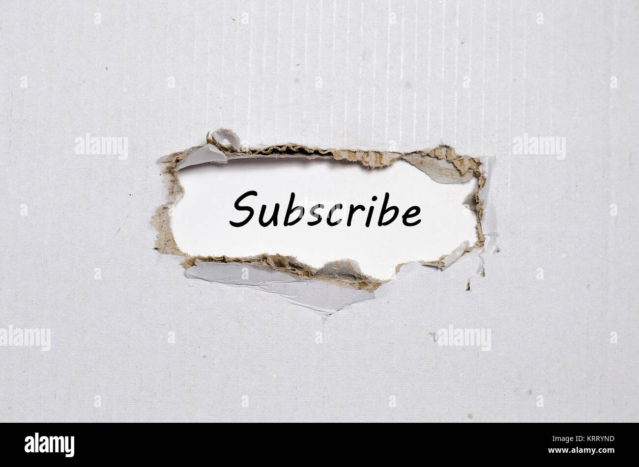 The word subscribe appearing behind torn paper Stock Photo
