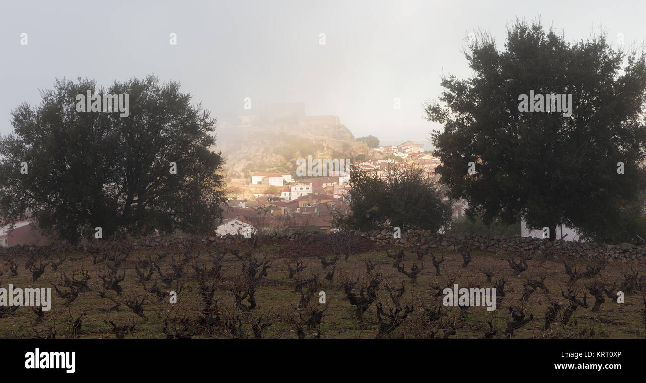 Panoramic view of the town of Montánchez in Extremadura. Spain. The castle of this village is seen covered by fog. Stock Photo