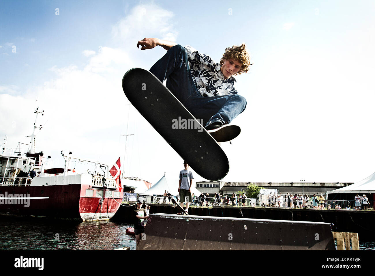 A skater is doing tricks on his skate board at a half pipe ramp in Stock  Photo - Alamy
