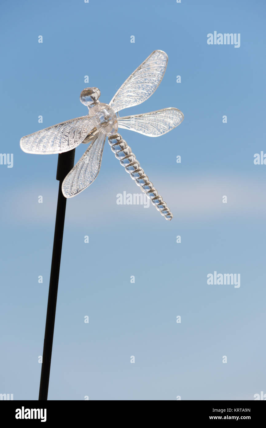 crystal dragonfly yard ornament with blue sky background Stock Photo