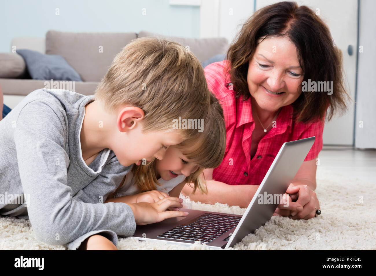 Multi Generation Family Using Laptop At Home Stock Photo