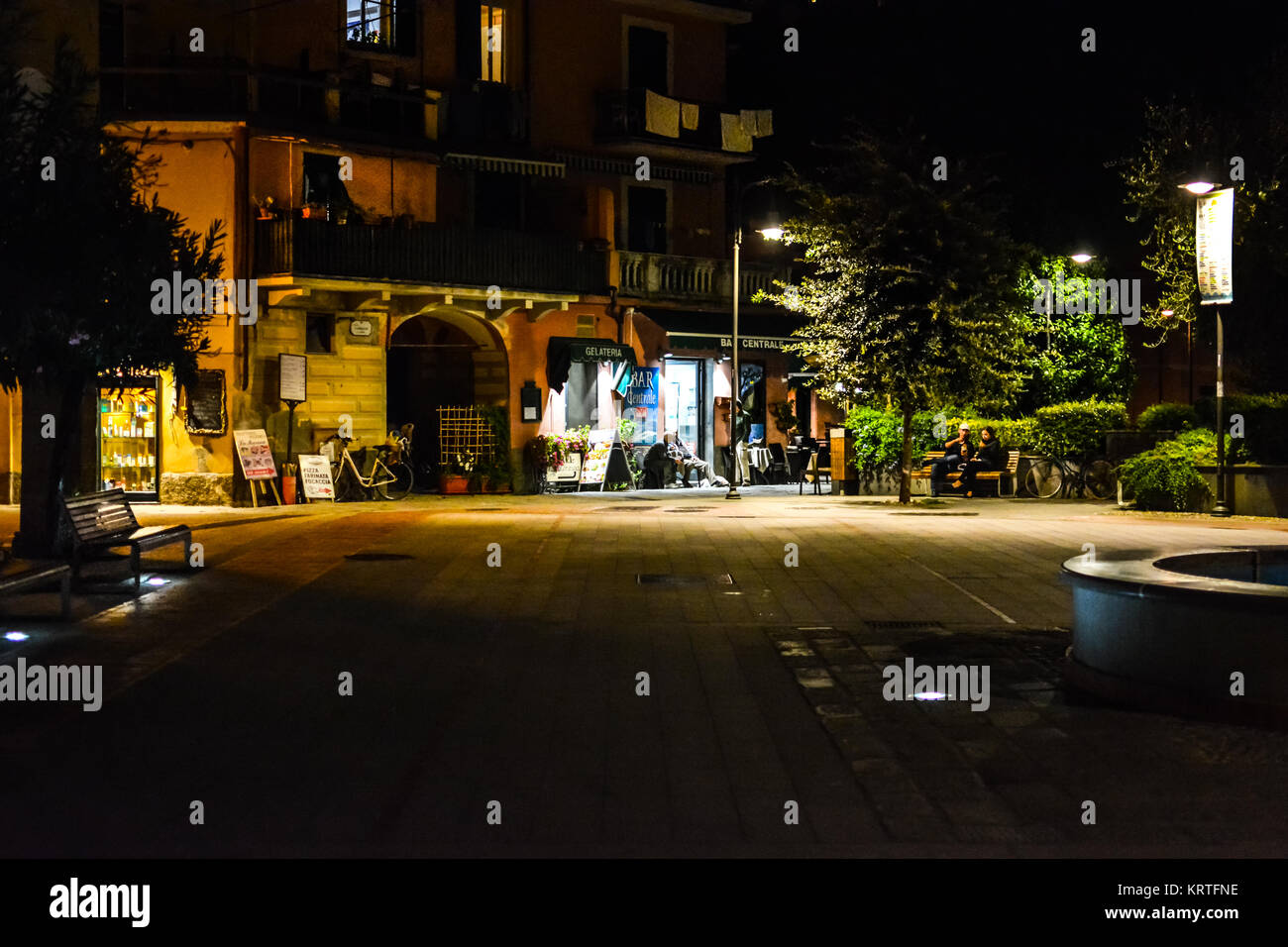 Late night at Garibaldi Square, the main town square of Monterosso Al Mare, Cinque Terre, with a few locals in front of a lighted shop Stock Photo